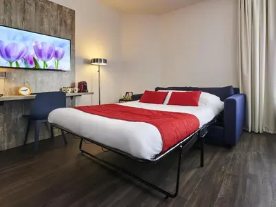 a bedroom with a large bed with red pillows at ibis Styles Almere in Almere