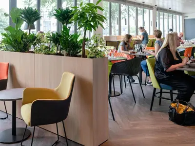 a group of people sitting at tables in a restaurant at ibis Styles Almere in Almere