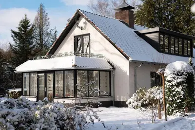 a white house with snow on the ground at Modern Palace Emma Staete in Baarn