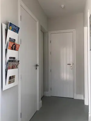 an empty hallway with a white door and magazines at Modern Palace Emma Staete in Baarn