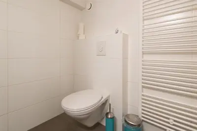 a white bathroom with a toilet and a shower at Quiet apartment for 4 at park in center in Amsterdam