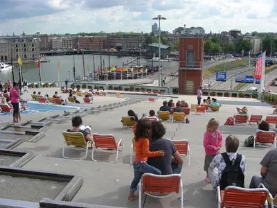 a group of people sitting in chairs near a pool at Quiet apartment for 4 at park in center in Amsterdam