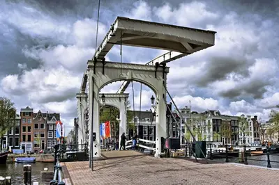 a bridge over a river with buildings in the background at Quiet apartment for 4 at park in center in Amsterdam