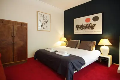 a bedroom with a large bed and a cabinet at Wooden Mill B&B in Amsterdam