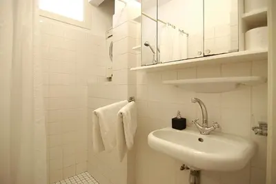 a white bathroom with a sink and a mirror at Wooden Mill B&B in Amsterdam
