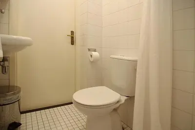 a white bathroom with a toilet and a shower at Wooden Mill B&B in Amsterdam