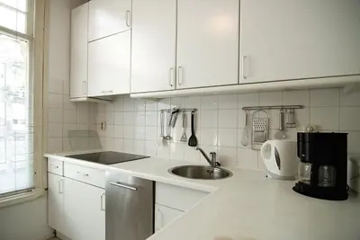 a kitchen with white cabinets and a sink at Wooden Mill B&B in Amsterdam