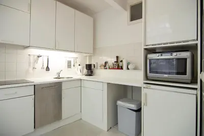 a kitchen with white cabinets and a microwave at Wooden Mill B&B in Amsterdam
