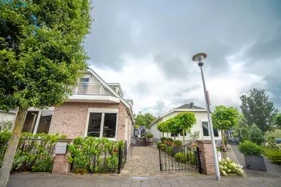 a brick house with a fence and a street light at Studio Pit-Stop in Zandvoort