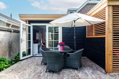 a patio with a table with an umbrella at Studio Pit-Stop in Zandvoort