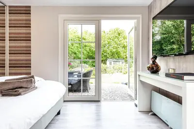 a bedroom with a bed and a sliding glass door at Studio Pit-Stop in Zandvoort