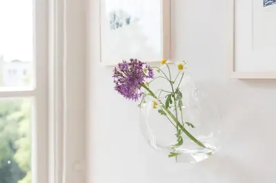 a vase with purple flowers on a window sill at Empire suites garden view in Amsterdam