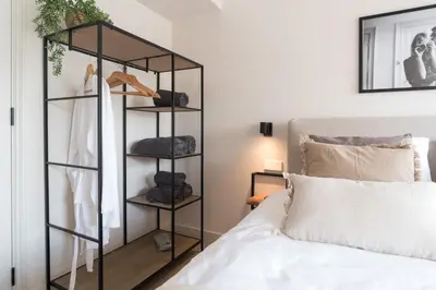 a bedroom with a black bookcase next to a bed at Empire suites garden view in Amsterdam
