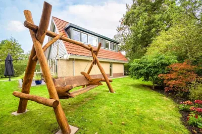 a wooden swing in the yard of a house at Ferienhaus Weitblick in Sint Maarten