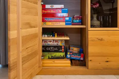 a book cabinet with books and games in it at Ferienhaus Weitblick in Sint Maarten