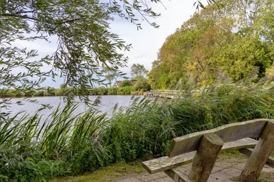 a wooden bench sitting in front of a lake at Ferienhaus Weitblick in Sint Maarten