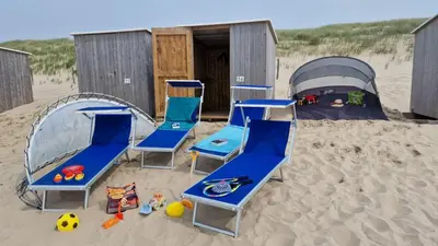a group of chairs and a tent in the sand at Ferienhaus Weitblick in Sint Maarten
