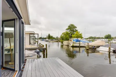a dock with boats docked at a marina at Bright and Comfortable Houseboat in Aalsmeer