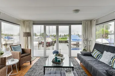a living room with a couch and a table at Bright and Comfortable Houseboat in Aalsmeer