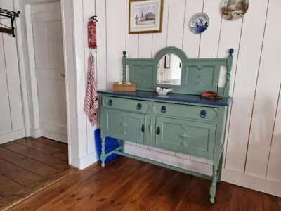 a green dresser in a room with a mirror at Bed & Breakfast De Koegang in Zuidermeer