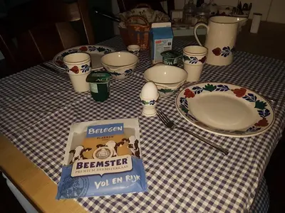 a table with a checkered table cloth with a plate andacistacistacist at Bed & Breakfast De Koegang in Zuidermeer