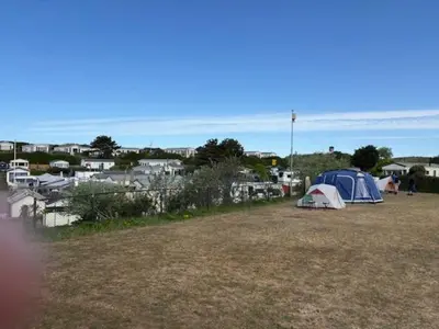 a group of tents in a field with houses at Chalet De Duinberg in IJmuiden