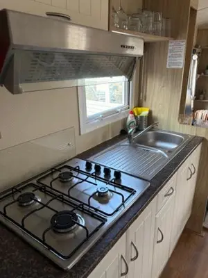 a kitchen with a stove top and a sink at Chalet De Duinberg in IJmuiden