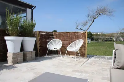 two white chairs sitting next to a fence at Chalet De Duinberg in IJmuiden