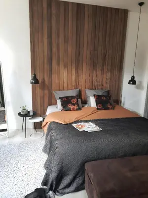 a bedroom with a large bed with a wooden headboard at Inn the Green in Zeist