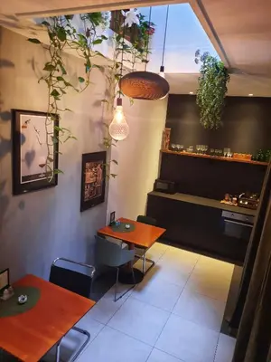 a dining room with tables and plants on the wall at Inn the Green in Zeist