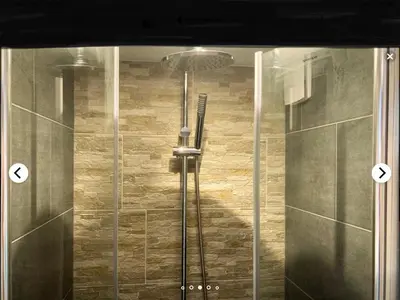 a shower in a bathroom with a glass door at Design BB Bed&Bike holiday cottage Tiny Home in Spakenburg in Spakenburg