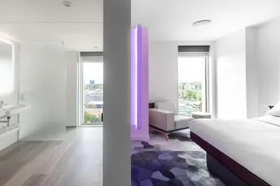 a hotel room with a bed and a bathroom at YOTEL Amsterdam in Amsterdam