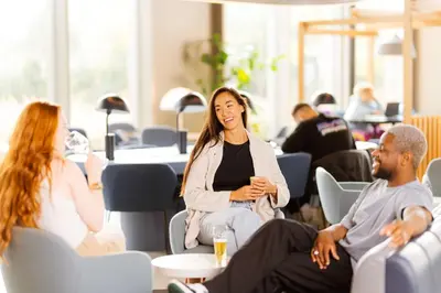 a group of people sitting in chairs in a room at YOTEL Amsterdam in Amsterdam