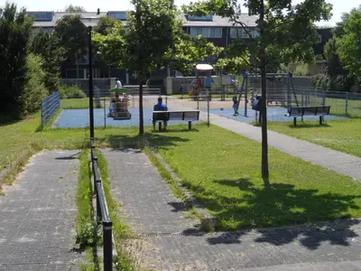 a park with people sitting on benches and a playground at Apartment Amsterdam New West - Free parking in Amsterdam