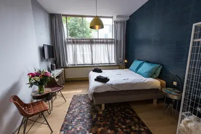 a bedroom with a bed with a blue wall at Amsterdam House of Arts & Crafts in Amsterdam