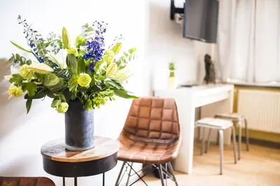 a vase of flowers on a table in a kitchen at Amsterdam House of Arts & Crafts in Amsterdam
