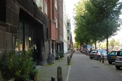 a street with cars parked on the side of a building at Amsterdam House of Arts & Crafts in Amsterdam