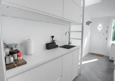 a white kitchen with a sink and a counter at Waterland Hoge Huis in Monnickendam