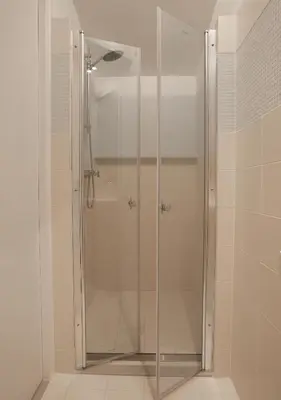 a shower with a glass door in a bathroom at Waterland Hoge Huis in Monnickendam
