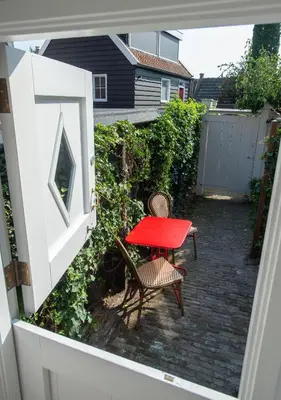 a red table and chairs on a patio at Waterland Hoge Huis in Monnickendam