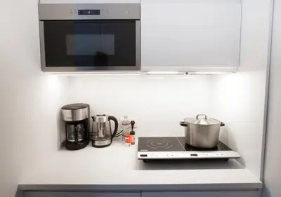 a kitchen counter with a stove and a microwave at Waterland Hoge Huis in Monnickendam