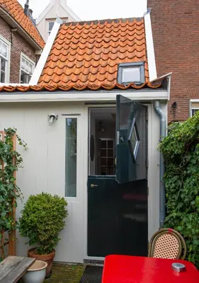 a small house with a black door and an orange roof at Waterland Hoge Huis in Monnickendam