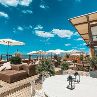 a outdoor patio with tables and chairs and umbrellas at casa Heemskerk in Noordwijk