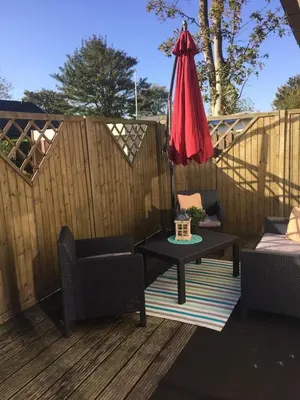 a patio with a table and an umbrella and chairs at Haus zum Leuchtturm Ferienpark Vislust Niederlande Ijsselmeer in Wervershoof