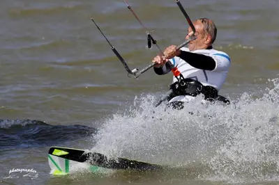 a man on a surfboard in the water at Haus zum Leuchtturm Ferienpark Vislust Niederlande Ijsselmeer in Wervershoof