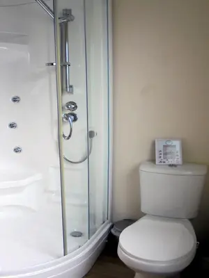 a bathroom with a toilet and a glass shower at Haus zum Leuchtturm Ferienpark Vislust Niederlande Ijsselmeer in Wervershoof