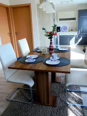 a dining room with a table and white chairs at Haus zum Leuchtturm Ferienpark Vislust Niederlande Ijsselmeer in Wervershoof