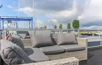 a wicker couch and chairs sitting on a boat at Madrid in Lelystad