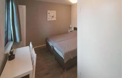 a small bedroom with a bed and a table at Pet Friendly Home In Zeewolde With Wifi in Zeewolde