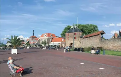 a woman sitting in a chair on a street next to a building at Pet Friendly Home In Zeewolde With Wifi in Zeewolde